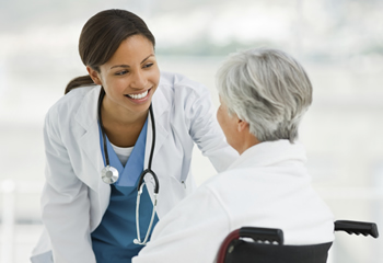 Photo of a female nurse helping a patient in a wheelchair